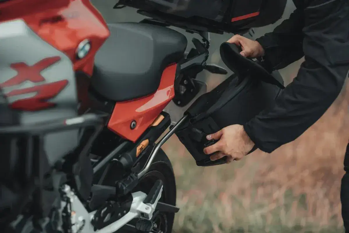 Przygotowanie do wyprawy: montaż sakwy do motocykla na malownicze **trasy motocyklowe Wielkopolska**.