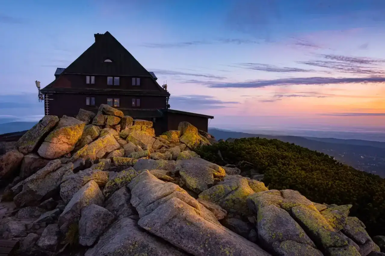 Schronisko na Szrenicy o zachodzie słońca, skaliste zbocze. Zastanawiasz się, którym szlakiem zejść ze Szrenicy?