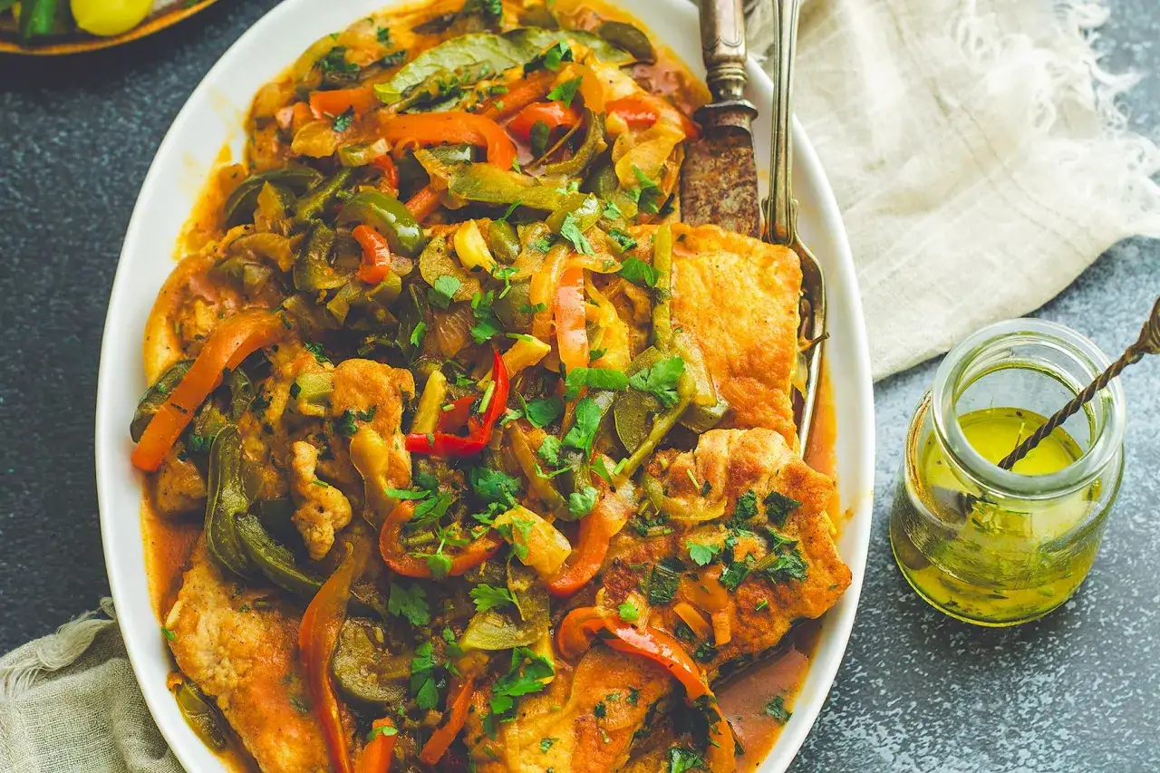 Schab w sosie z papryką i cebulą, idealny pomysł na obiad. Danie posypane natką pietruszki.