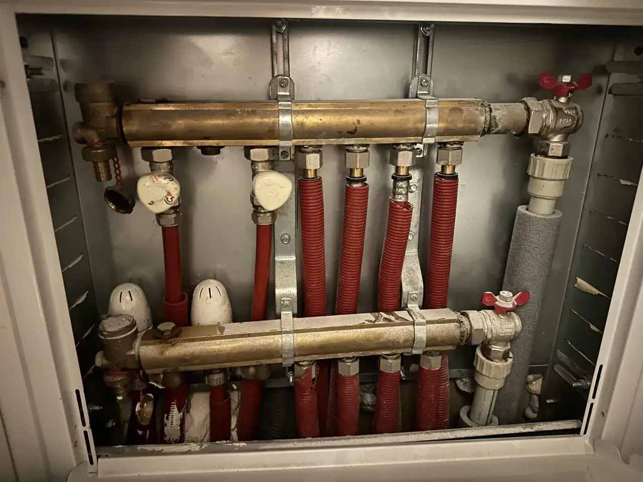 Rozdzielacz ogrzewania podłogowego z zaworami. Dowiedz się, jak zakręcić ogrzewanie podłogowe, zamykając dopływ wody.