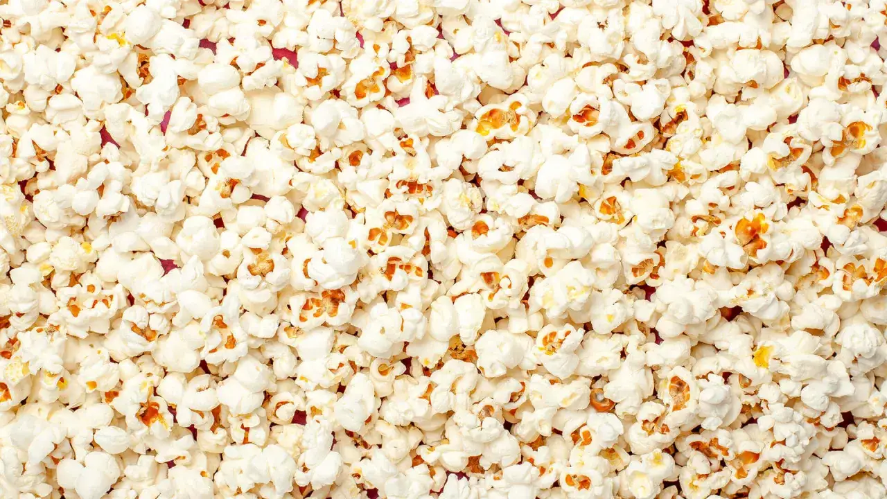 Mnóstwo puszystego popcornu, idealnego na wieczór filmowy. Czy pies może popcorn? Lepiej nie ryzykować, choć wygląda apetycznie!