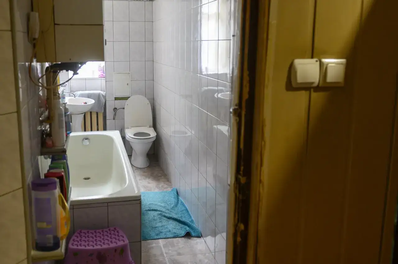 W łazience z wanną, toaletą i umywalką, widać, że lokal socjalny musi mieć łazienkę.