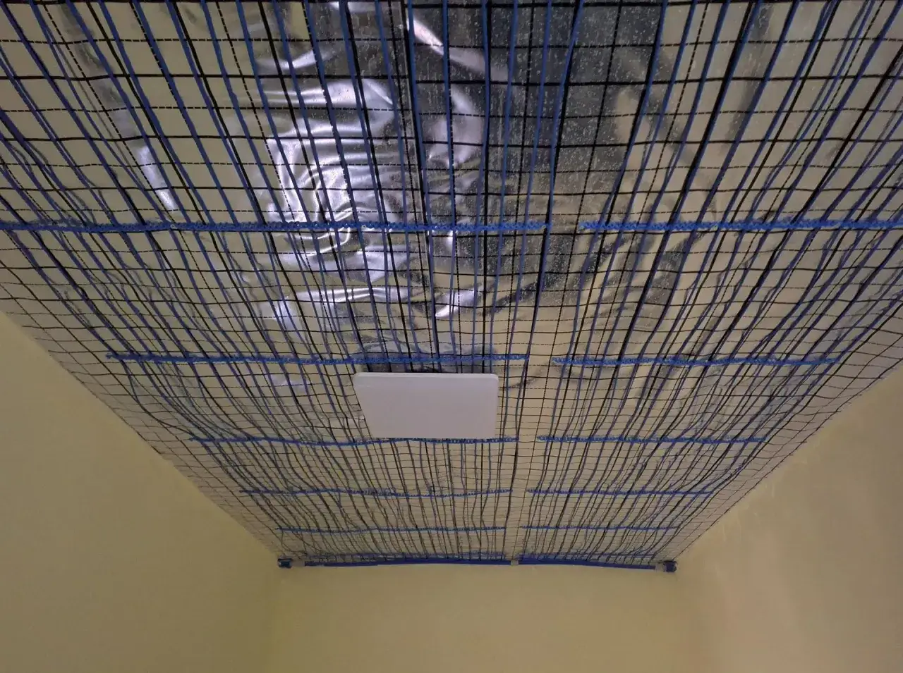 Sufit z siatką i folią izolacyjną, przygotowany pod montaż mat kapilarnych.