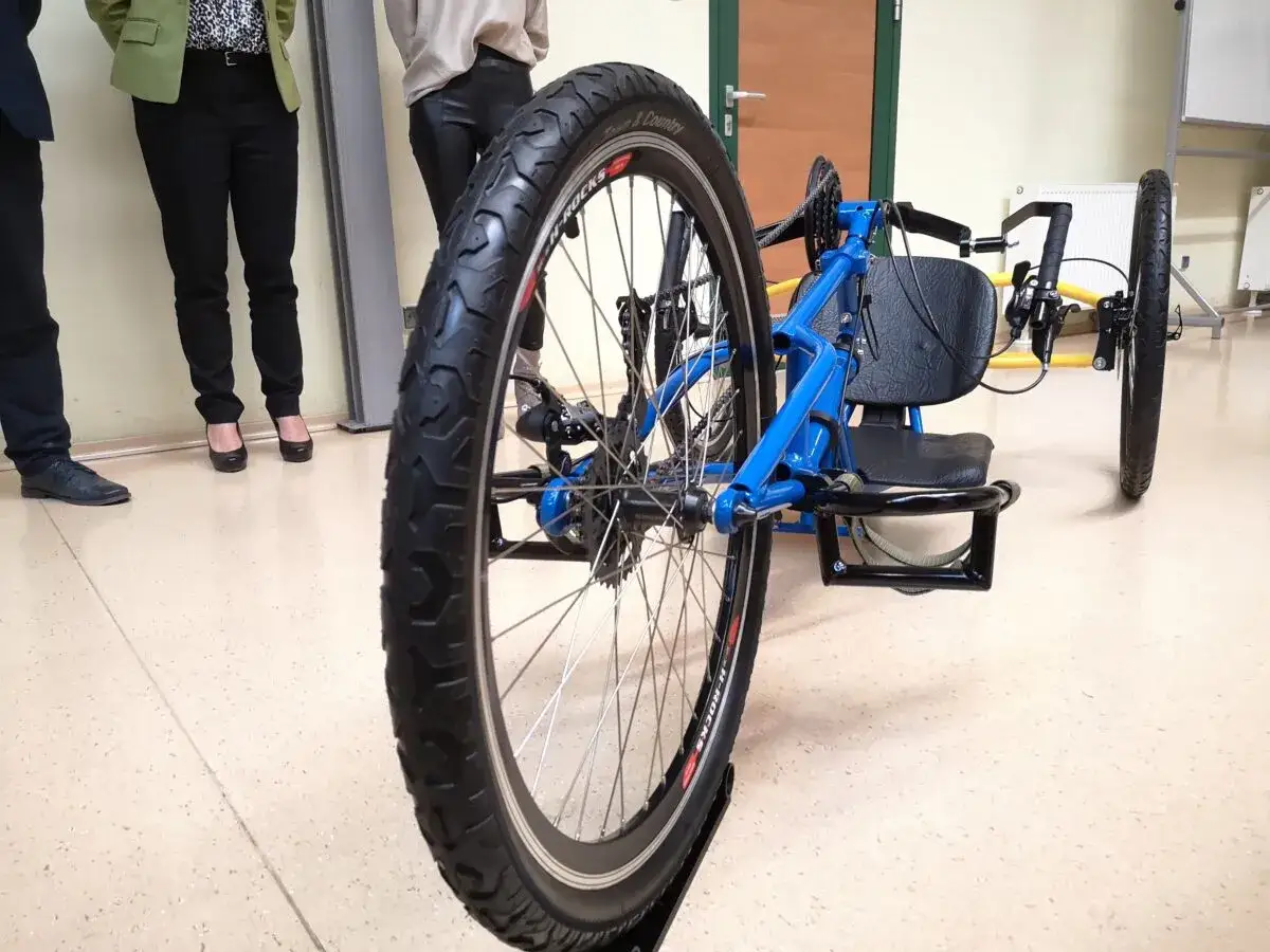 Niebieski prototyp roweru trójkołowego z dużym tylnym kołem i siedzeniem.