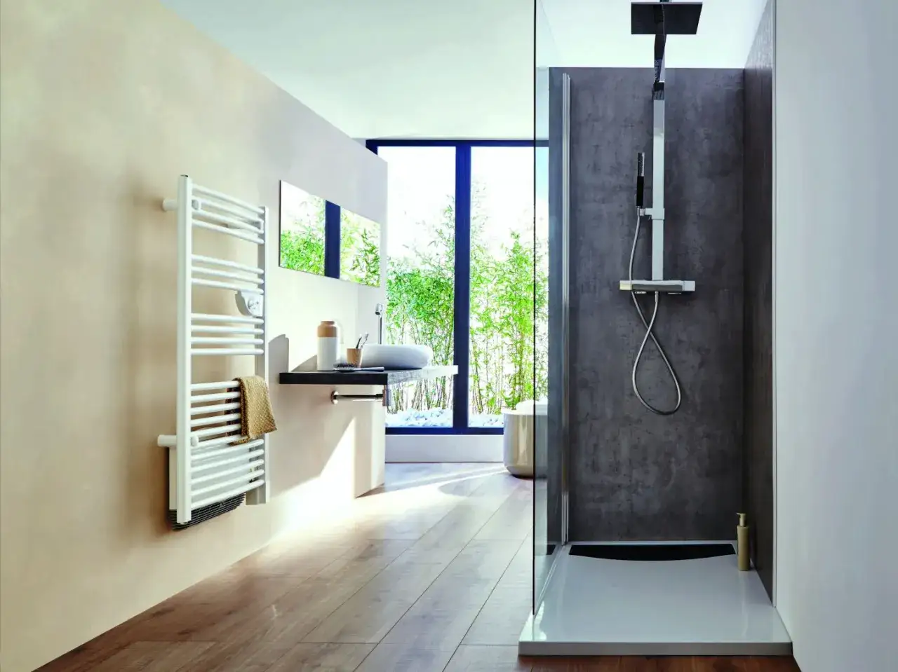 Biała suszarka na grzejnik łazienkowy z ręcznikiem w tle, obok umywalki i prysznica.