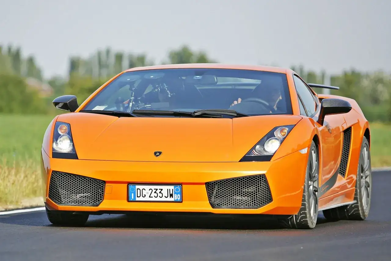 Pomarańczowe Lamborghini Gallardo na drodze.