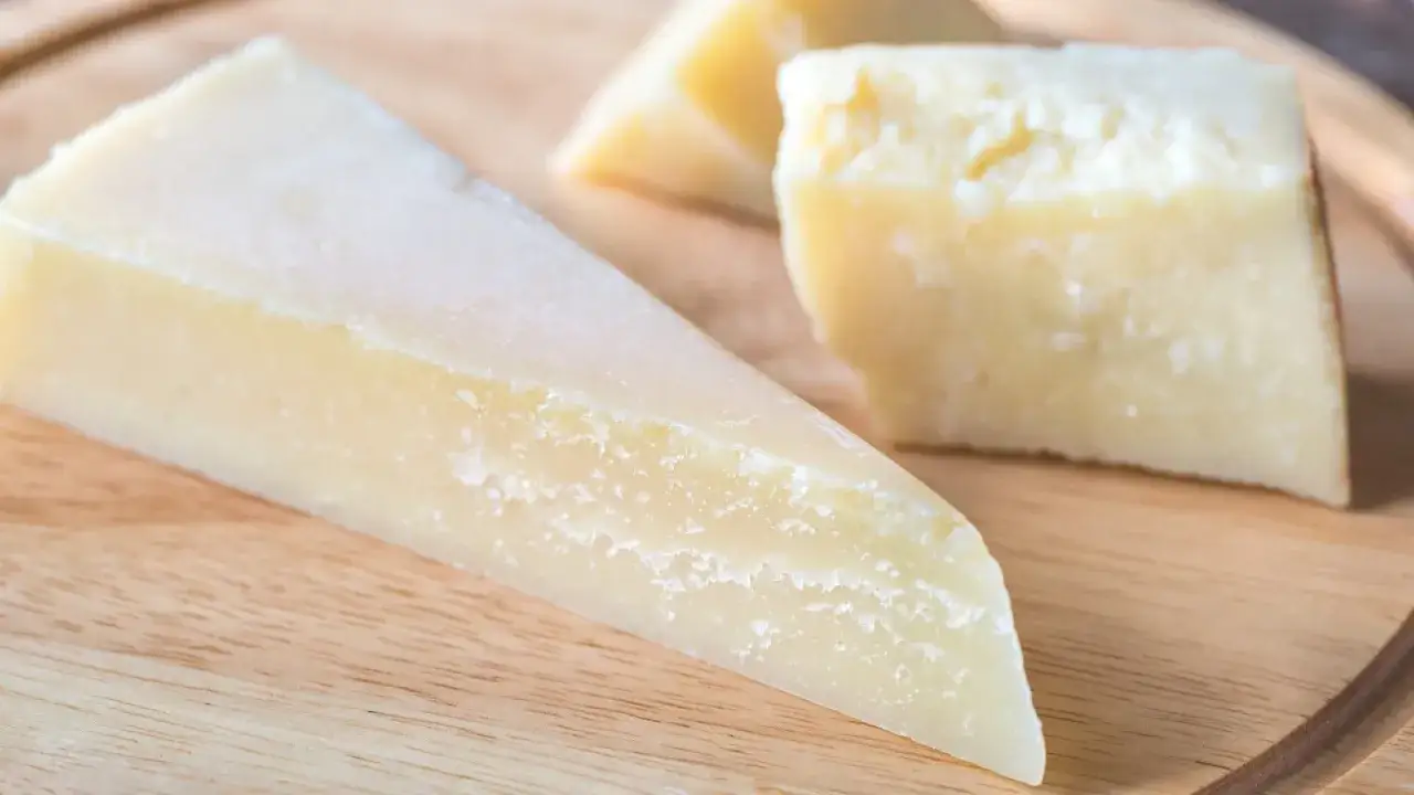 Kawałki twardego, żółtawego sera, które doskonale ilustrują, co to jest parmezan.