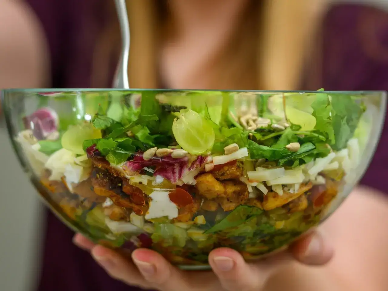 Miseczka sałatki gyros z kurczakiem, warzywami, serem i winogronami.