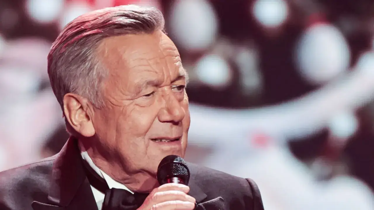 Roland Kaiser singt mit Mikrofon, im Anzug mit Fliege.