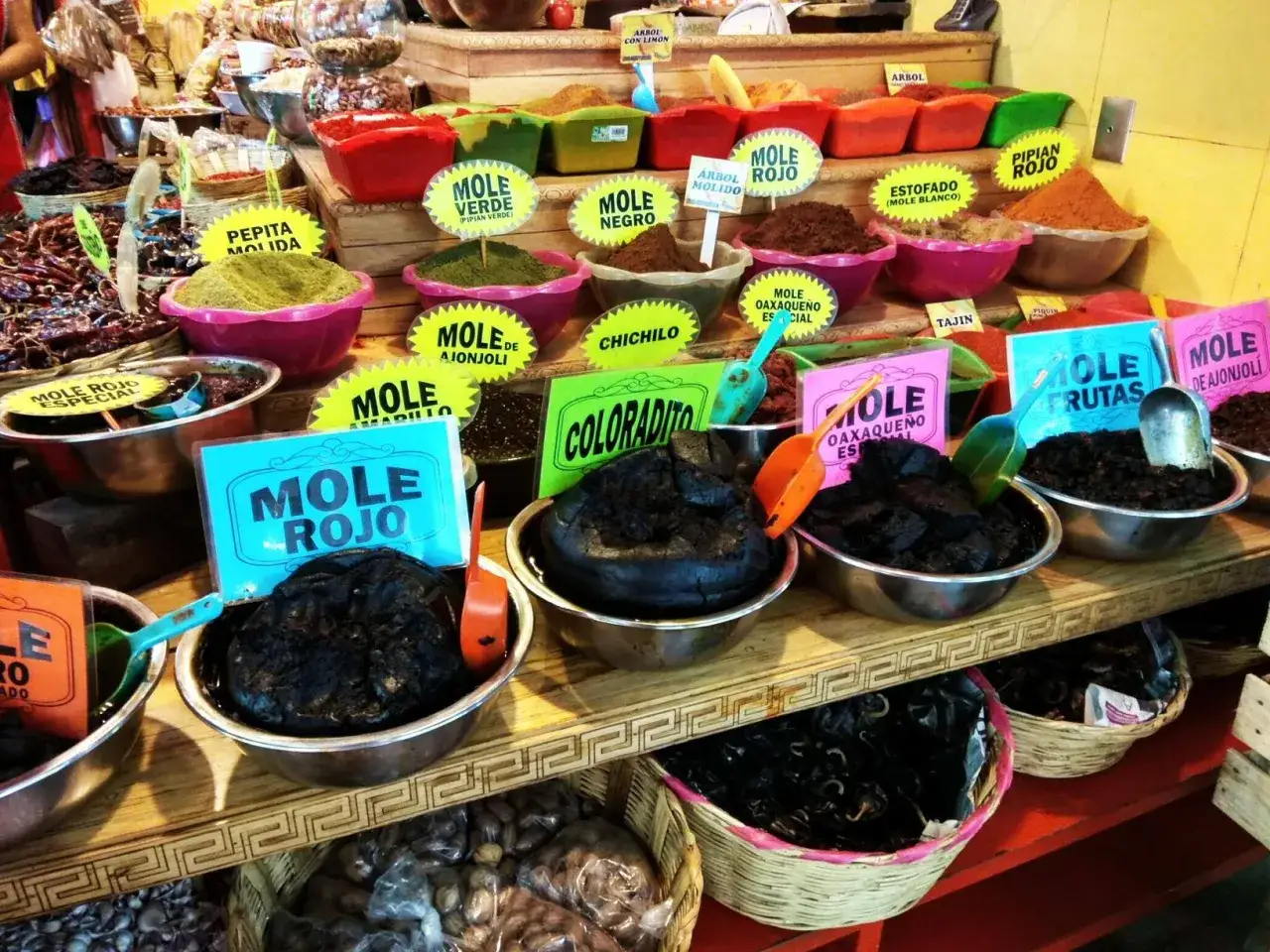 Kolorowe misy z różnymi rodzajami mole i przyprawami. Idealne, by dowiedzieć się, co warto przywieźć z Meksyku.
