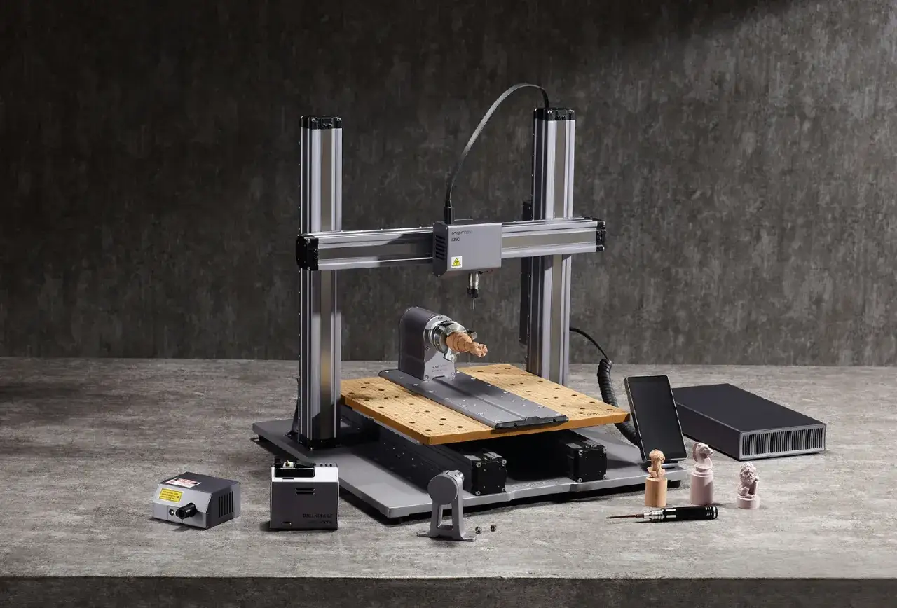 Drukarka 3D CNC z akcesoriami i wydrukowanymi figurkami.