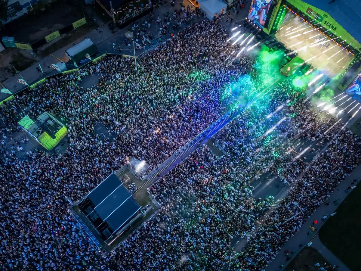 Tłum ludzi na koncercie podczas Łódź Summer Festival 2026. Kolorowe światła i dym tworzą niesamowitą atmosferę.