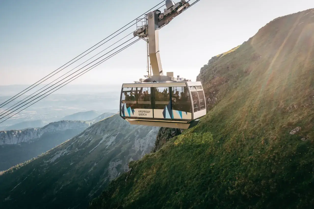 Kolejka linowa PKL Kasprowy Wierch wjeżdża na zbocze górskie, oferując pasażerom widok na Tatry.