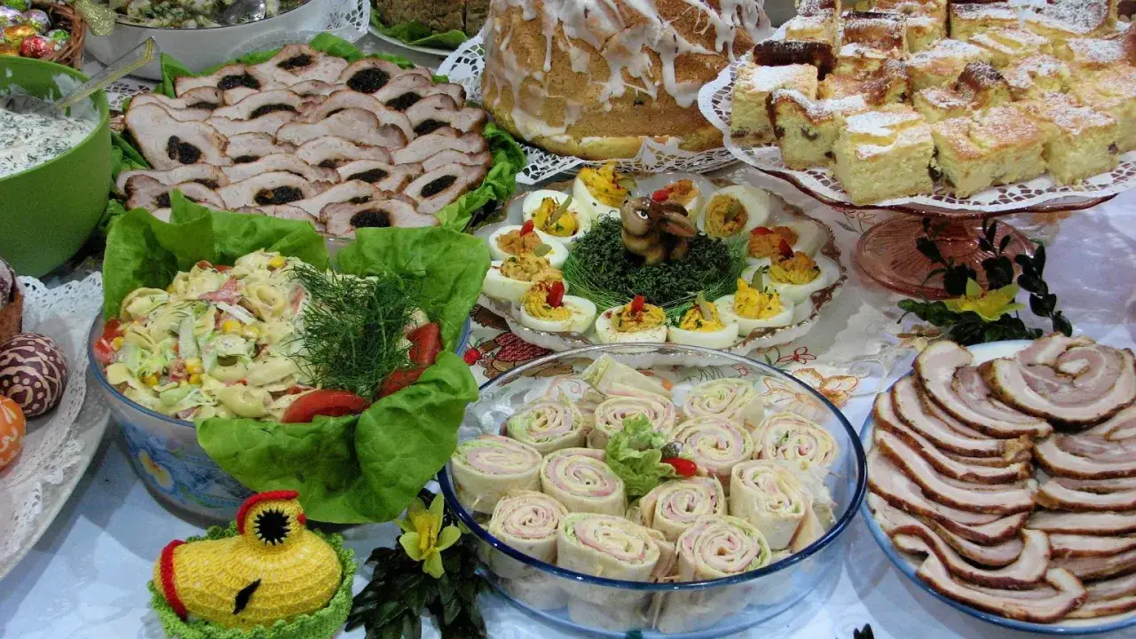 Mnóstwo pyszności na stole, idealnych na to, co ugotować na święta: pieczone mięsa, sałatki, jajka faszerowane, babka i ciasta.