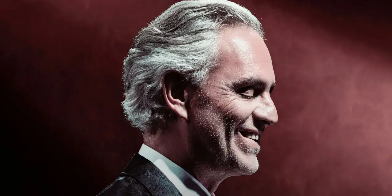 Uśmiechnięty Andrea Bocelli w garniturze. Zastanawiasz się, ile trwa koncert Andrea Bocelli?