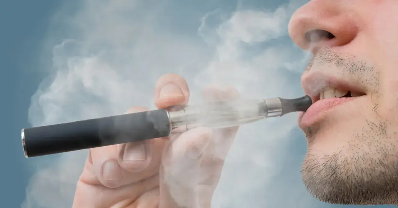 Mężczyzna zaciąga się e-papierosem. Pytanie brzmi: czy w hotelu można palić e papierosa?