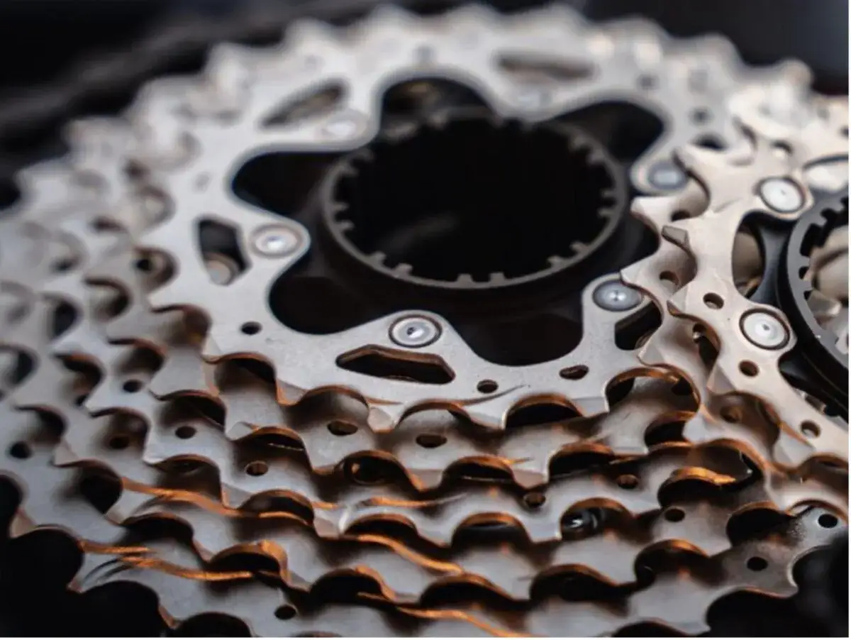 Zbliżenie na metalowe zębatki kasety rowerowej, ukazujące różne rodzaje kaset rowerowych.