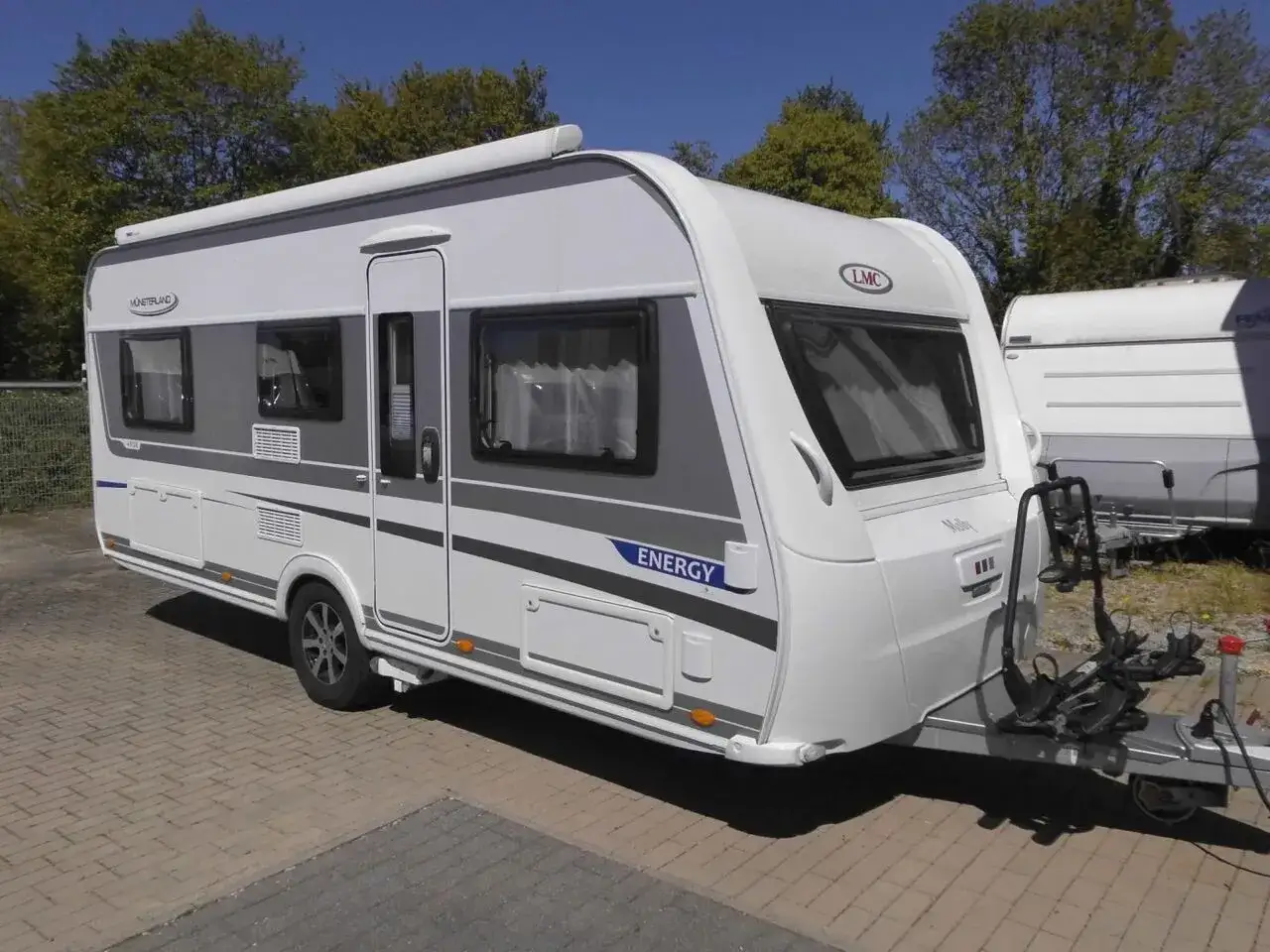 Nowy lmc caravan "Energy" gotowy na wakacje. Biało-szary, z bagażnikiem na rowery.