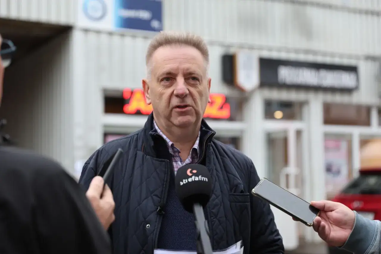 Mężczyzna udziela wywiadu, trzymając w ręku telefon. Może to być pomocne przy pisaniu odwołania do spółdzielni mieszkaniowej.