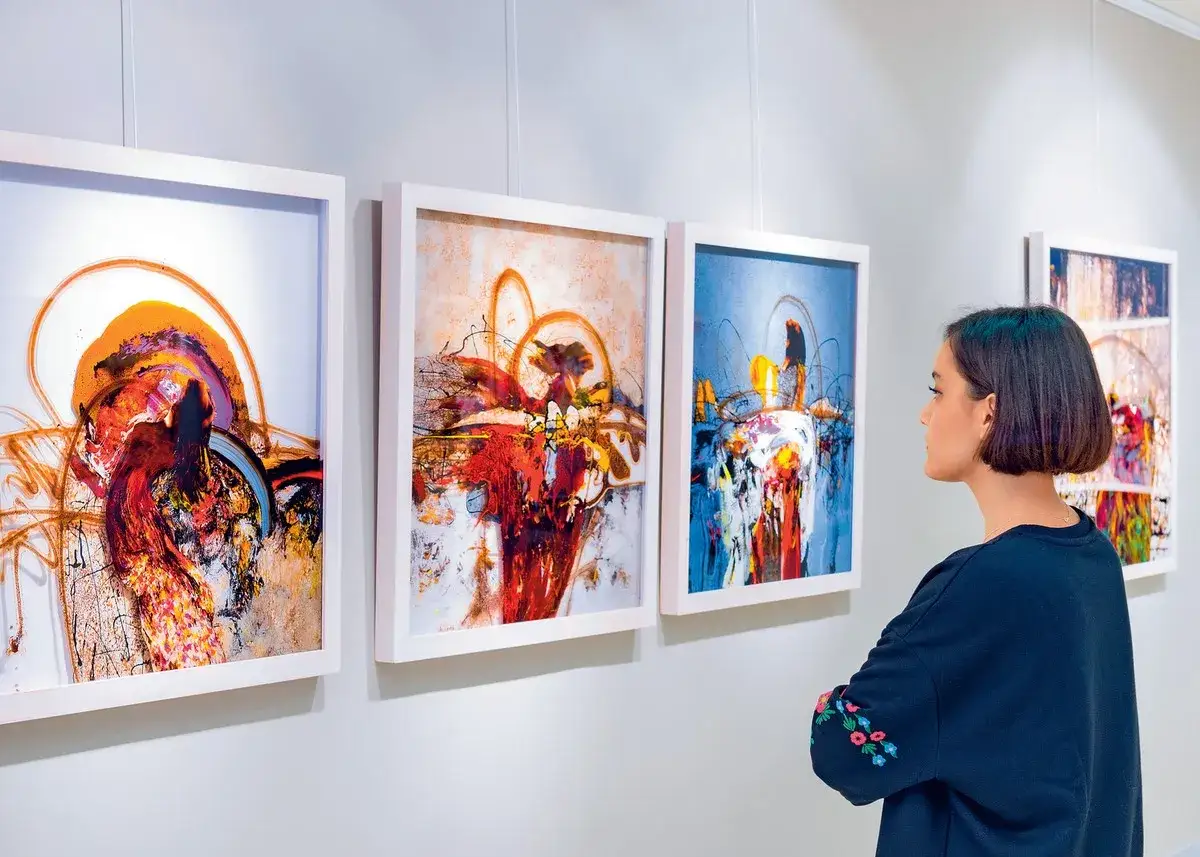 Kobieta ogląda abstrakcyjne obrazy w galerii sztuki.