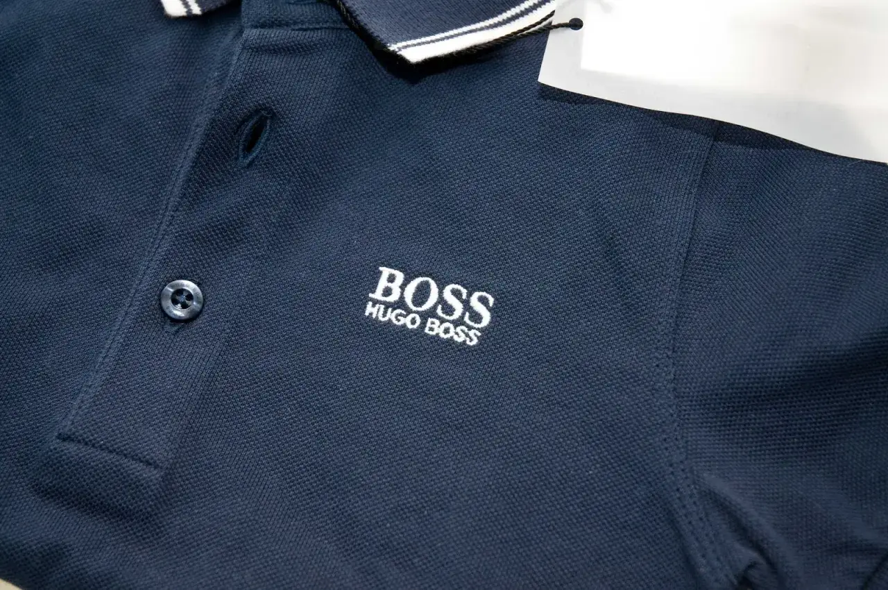 Granatowa koszulka polo z haftowanym logo BOSS HUGO BOSS. Widoczna oryginalna metka Hugo Boss.