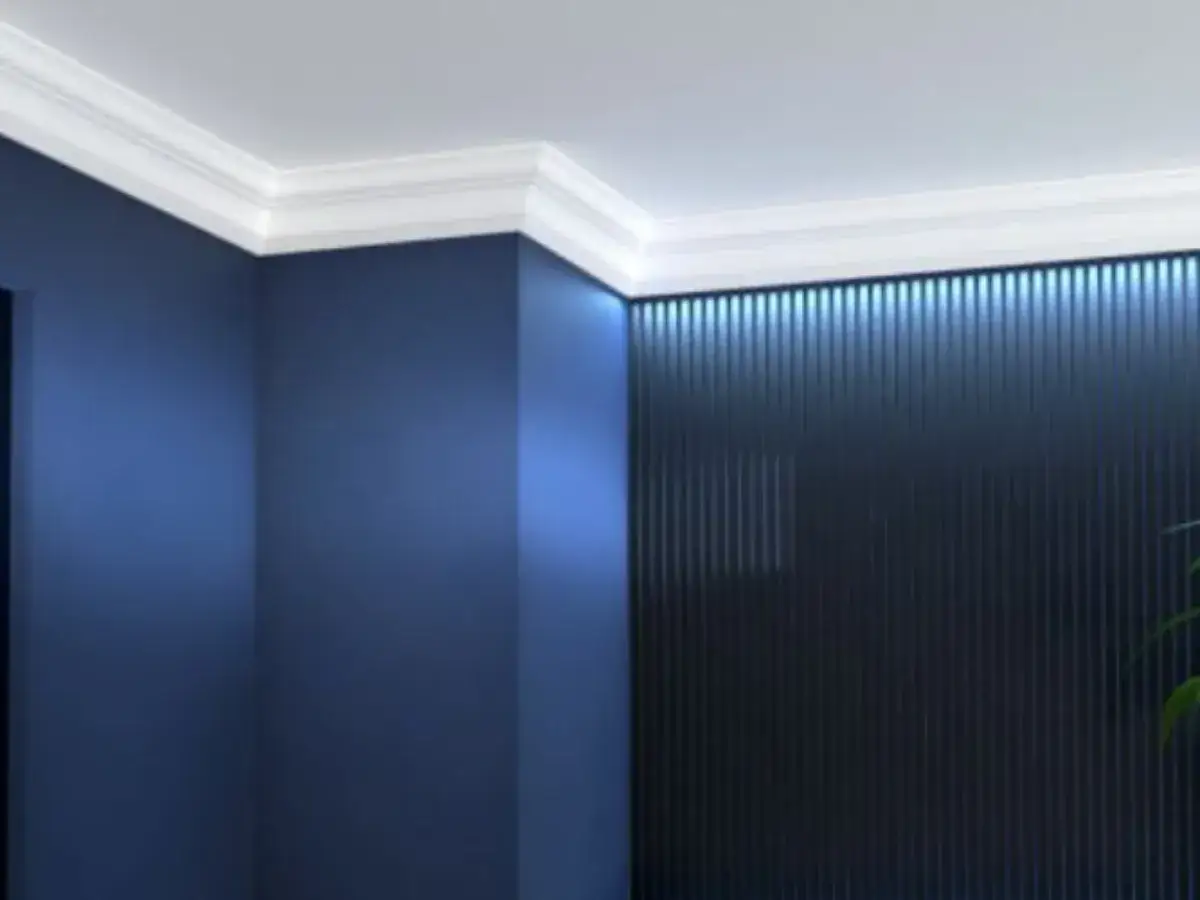 Elegancki biały pasek pod sufitem dodaje uroku granatowym ścianom i podkreśla nowoczesny charakter wnętrza.