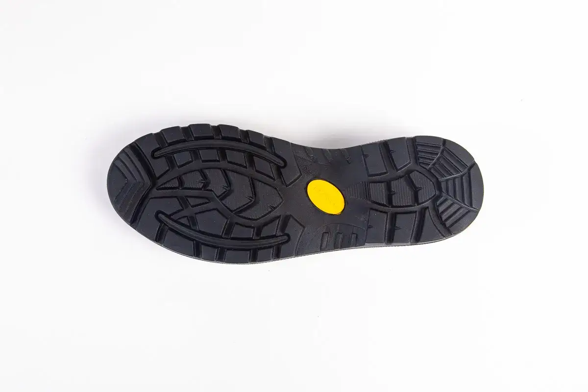 Czarna podeszwa buta z żółtym logo Vibram, gotowa do wymiany w butach, zapewniająca przyczepność.