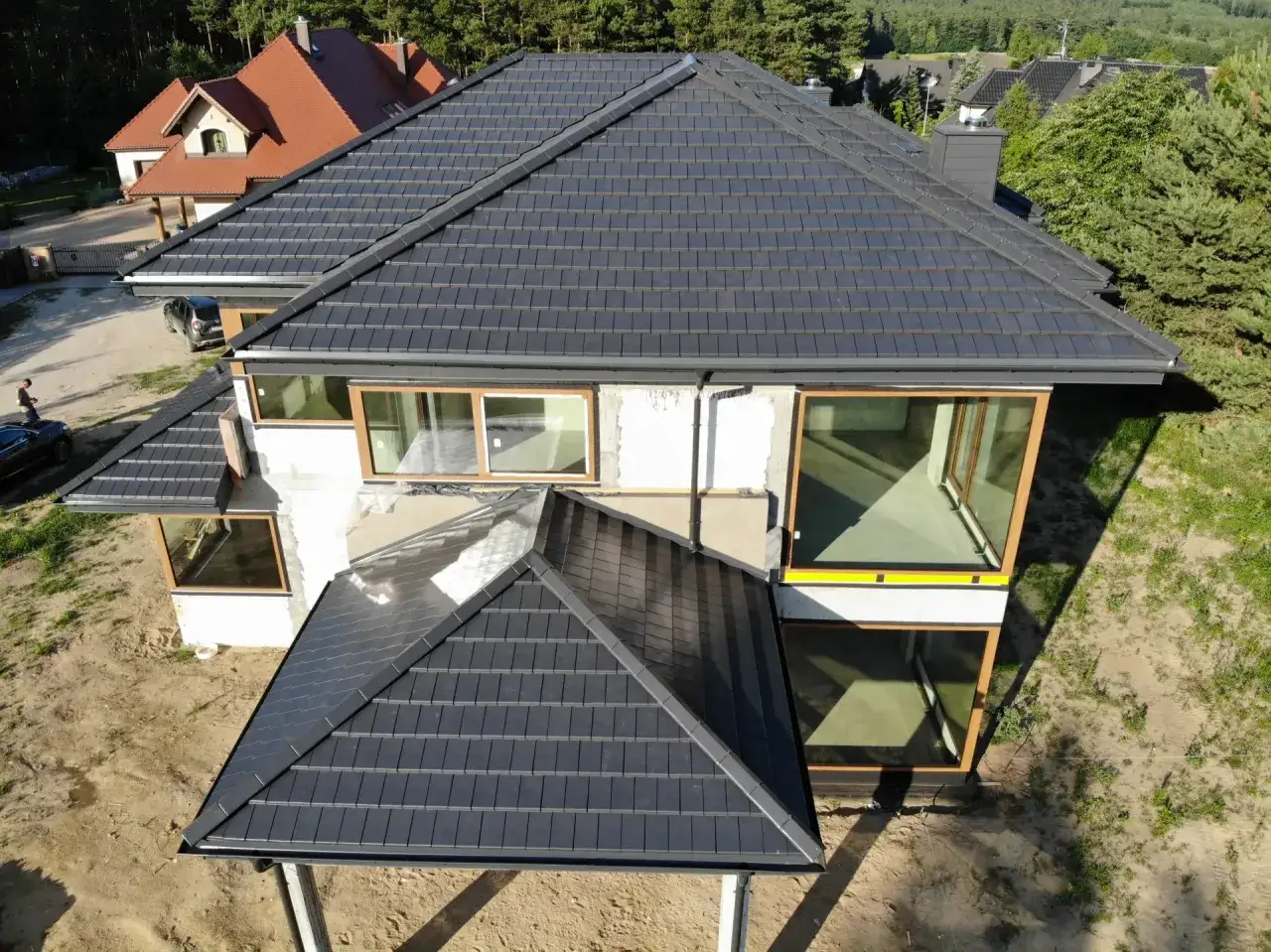 Nowy, ciemny dach z dachówki ceramicznej. Zastanawiasz się, ile kosztuje wymiana pokrycia dachowego?