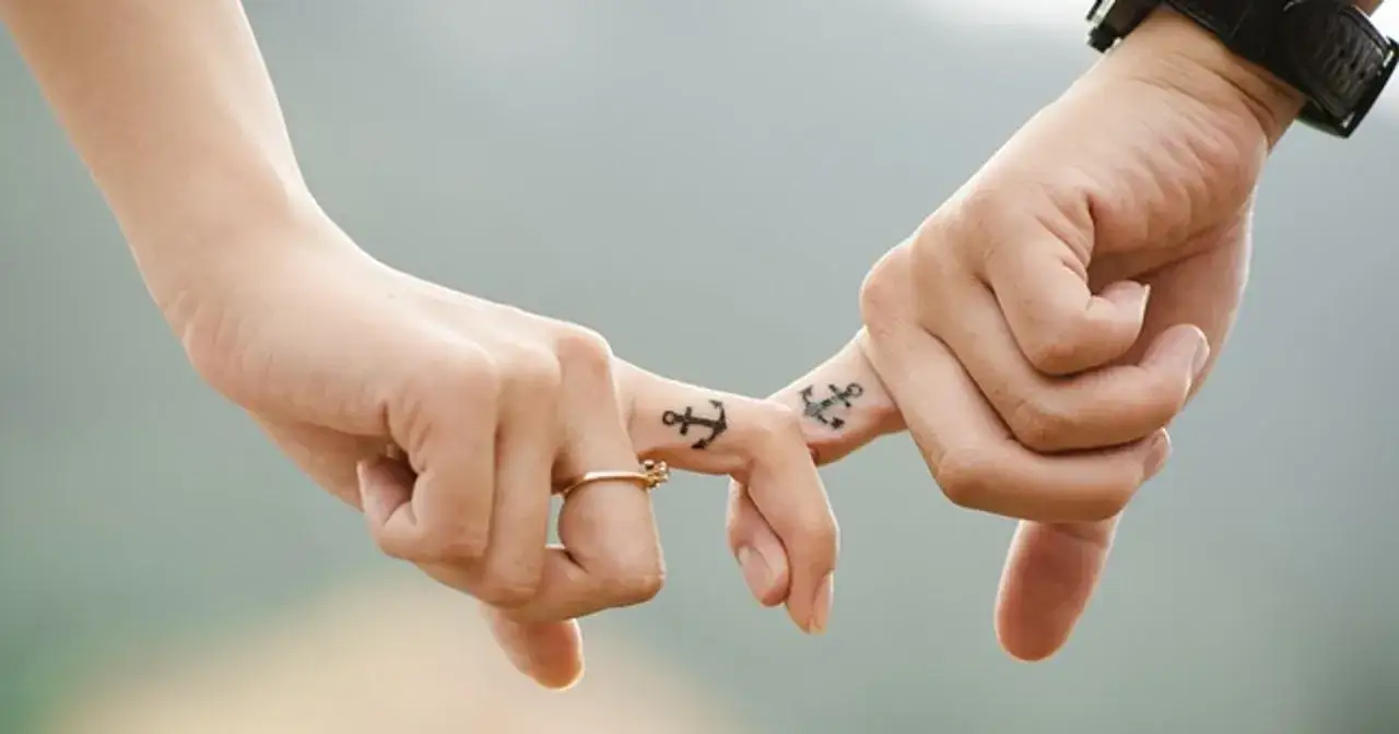 Dłoń z obrączką i tatuażem kotwicy, druga dłoń z kotwicą. Idealny prezent na dzień żony.
