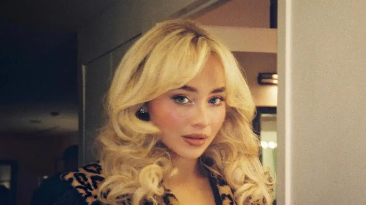 Frau mit voluminösem blondem Haar und Leopardenmuster-Jacke.