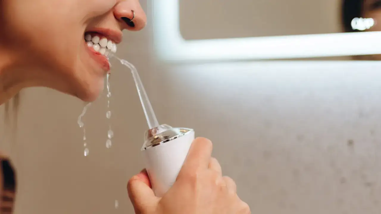 Kobieta używa irygatora. Zastanawiasz się, jaka woda do irygatora będzie najlepsza? Czysta woda to podstawa dla zdrowego uśmiechu.