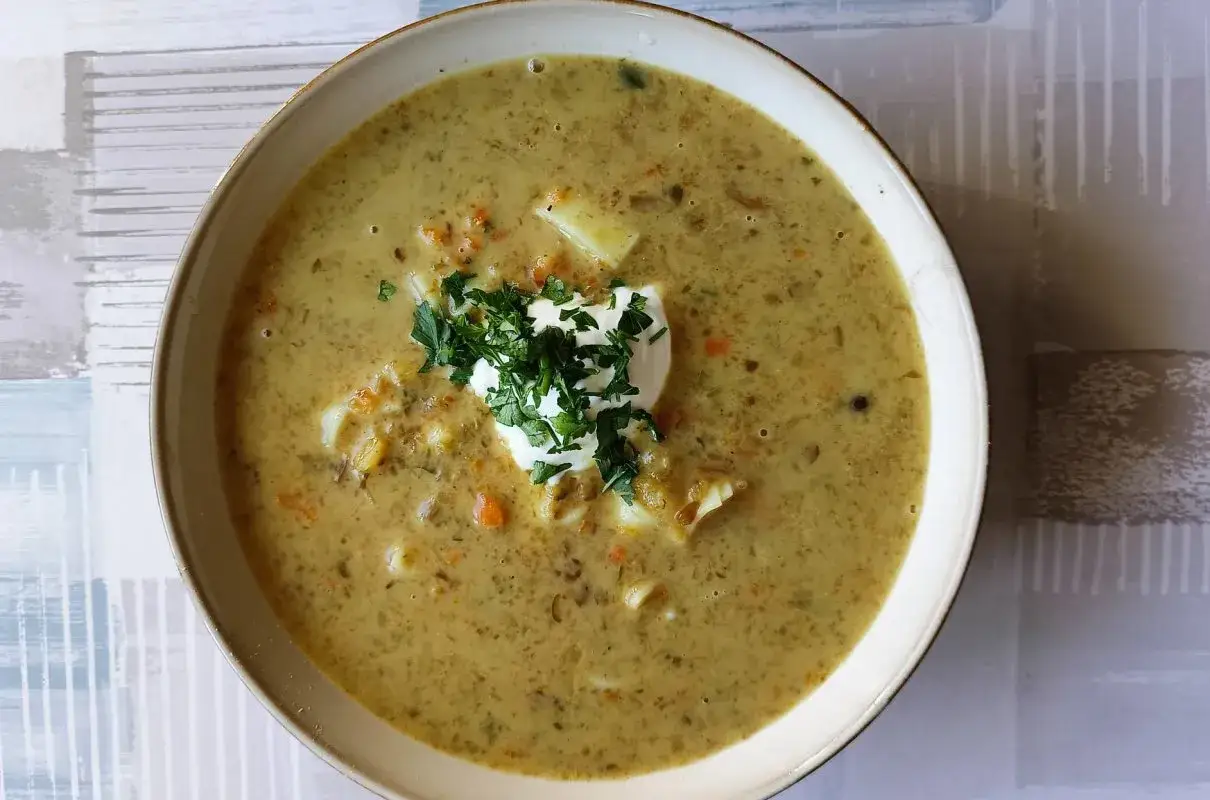 Miseczka zupy grzybowej ze śmietaną i natką pietruszki.