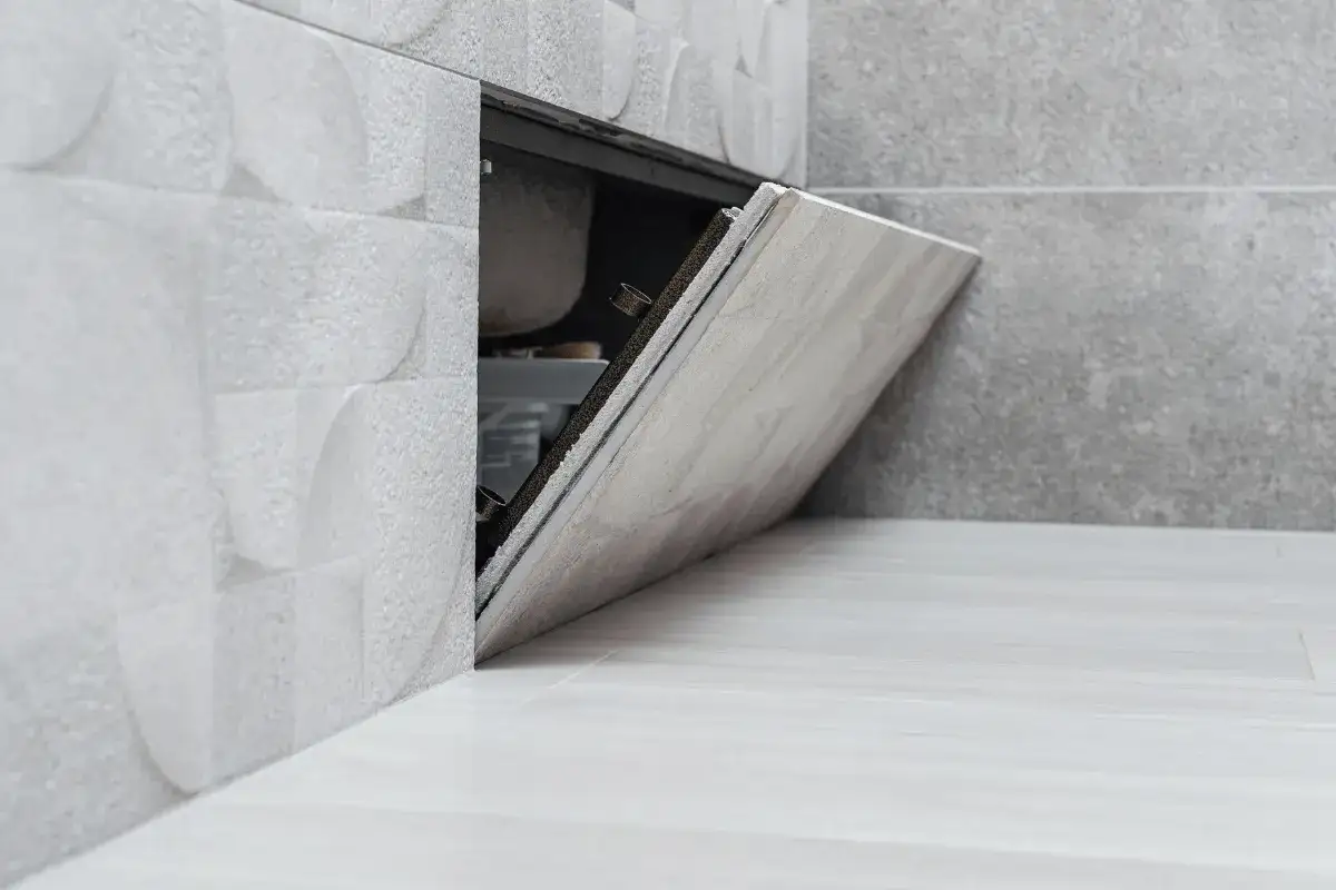 Otwarta klapka rewizyjna w łazience, pokazująca, jak zamontować drzwiczki rewizyjne plastikowe.