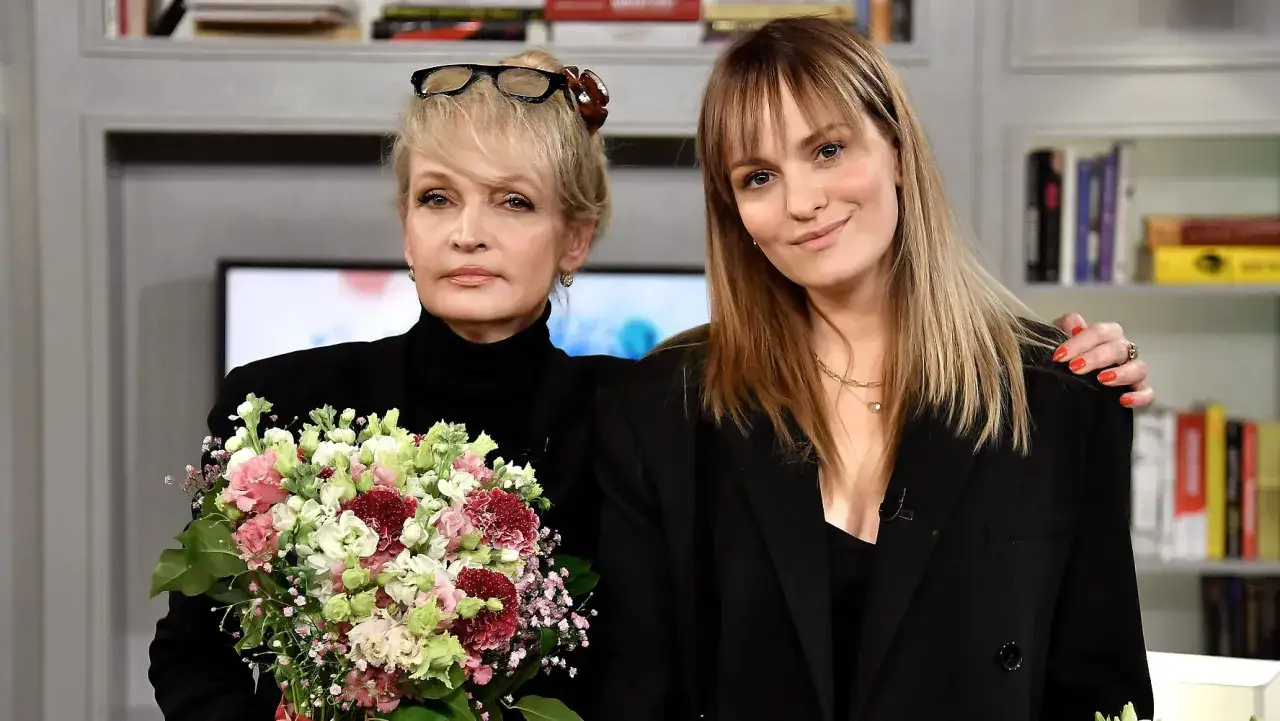 Joanna Biedrzyńska z córką, obie ubrane na czarno, z bukietem kwiatów.