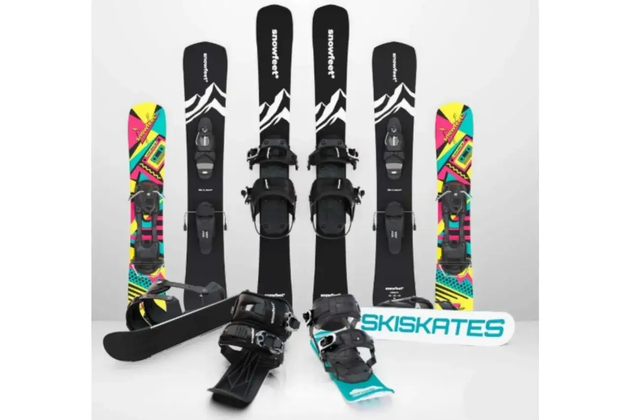 Narty do skakania i snowboardy z kolorowymi grafikami. Dwa zestawy nart do skakania z czarnymi wiązaniami i grafiką górską. Dwa snowboardy z kolorowymi wzorami.