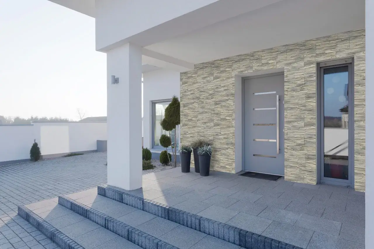 Kamien na klatce schodowej w domu, ozdobiony kamienną okładziną, tworzy eleganckie wejście.