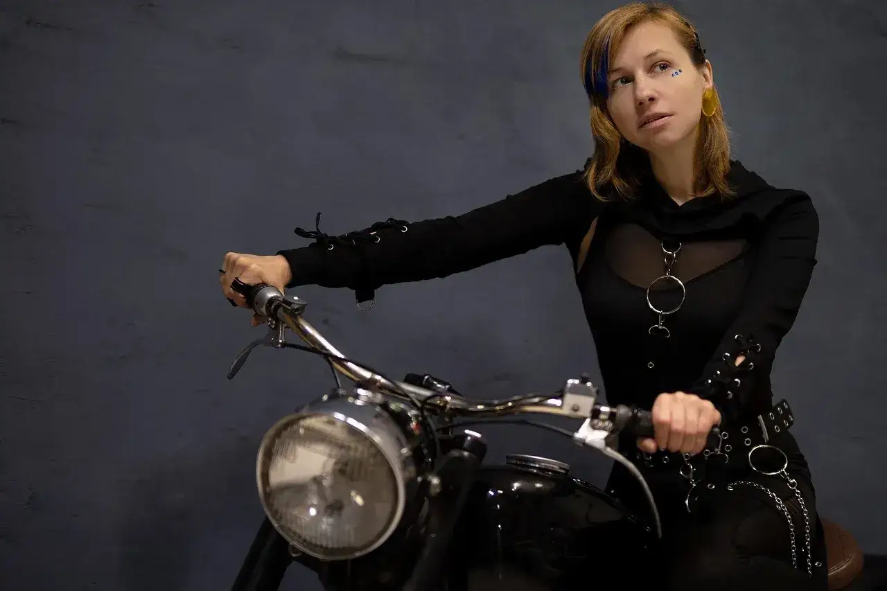Kobieta na motocyklu, gotowa na odkrywanie tras motocyklowych zachodniopomorskie. Stylowy strój i pewność siebie.