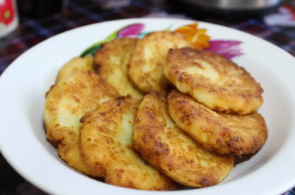 Placki ziemniaczane na talerzu z kwiatowym wzorem. Idealne co na obiad w środę, złociste i chrupiące.
