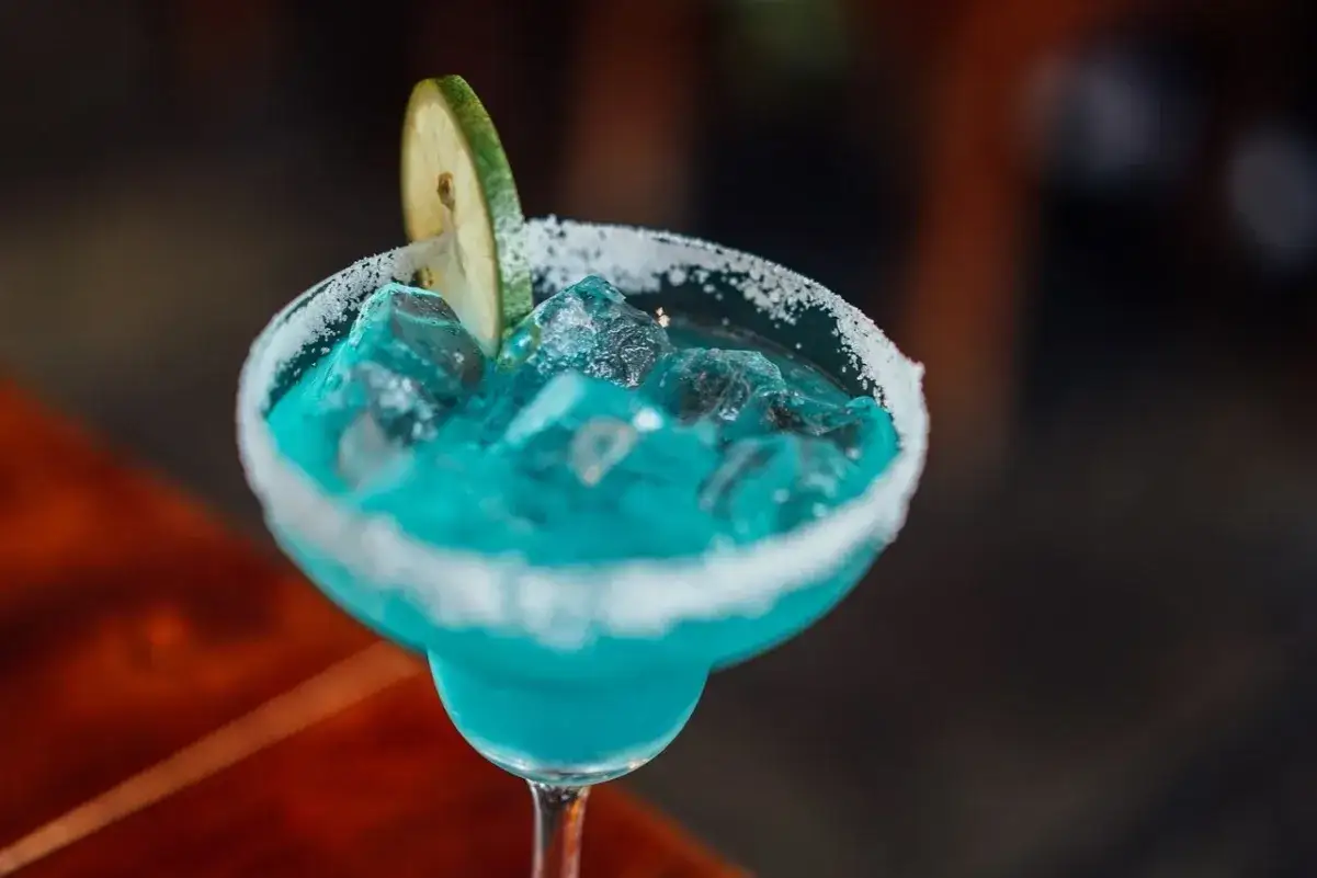 Orzeźwiający drink bezalkoholowy z blue curacao, lodem i plasterkiem limonki, z cukrowym rantem.