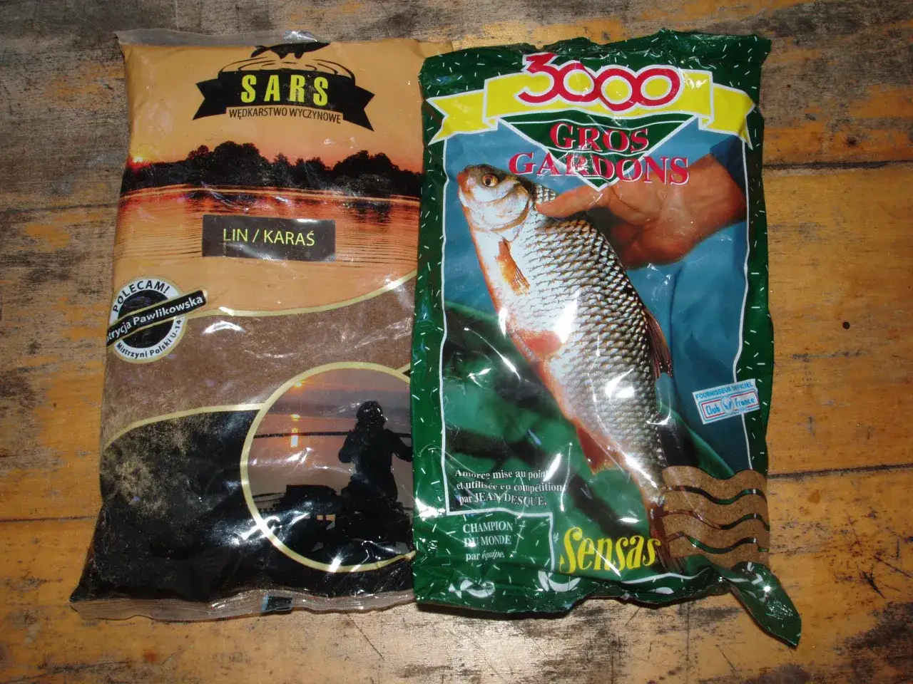 Dwie paczki zanęt wędkarskich: "Sars Lin/Karas" i "Sensas 3000 Gros Gardons", gotowe na połów.