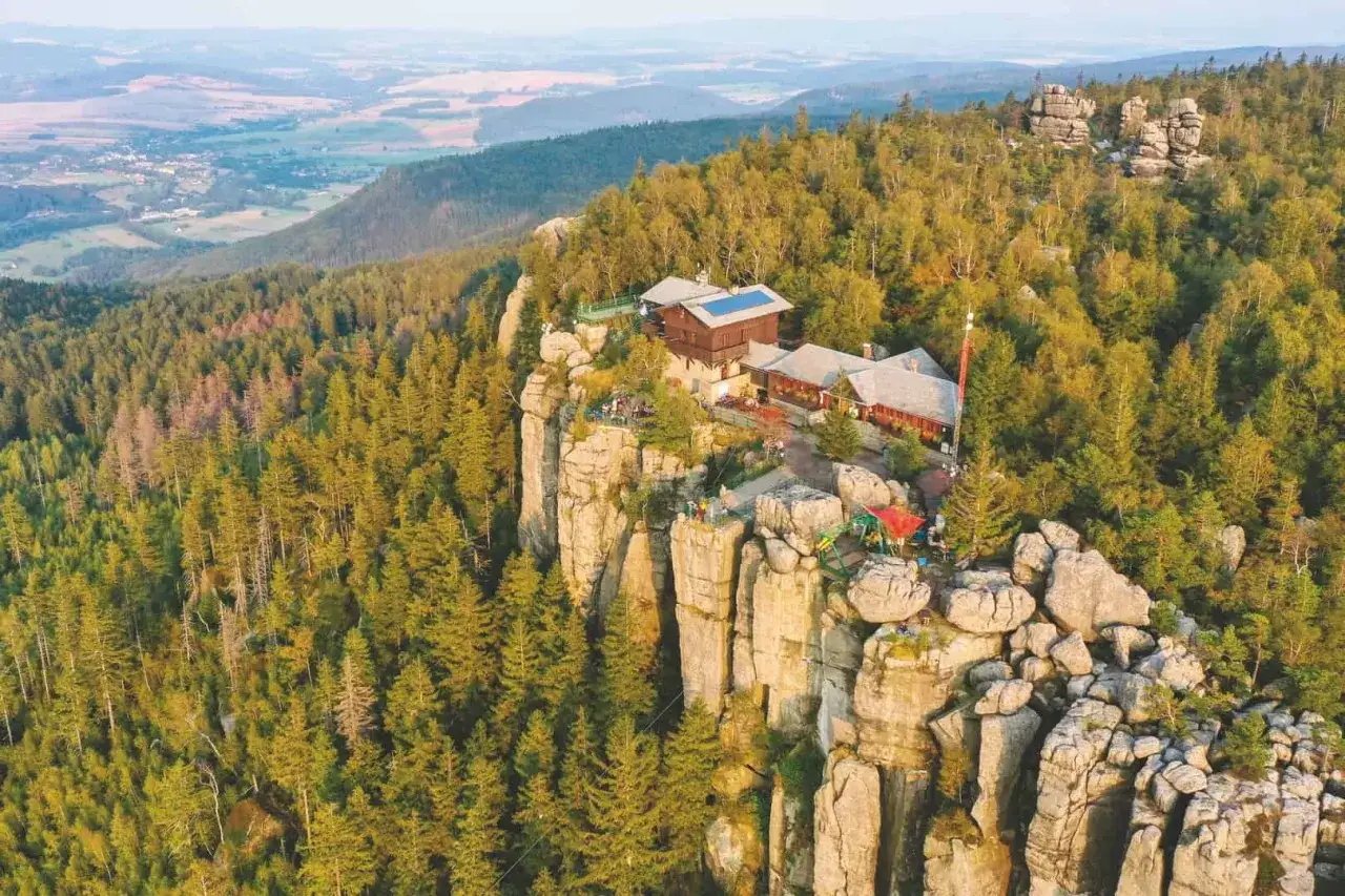 Widok na Szczeliniec Wielki. Idealny czas zwiedzania to lato, gdy można podziwiać piękne widoki i odpocząć w schronisku.