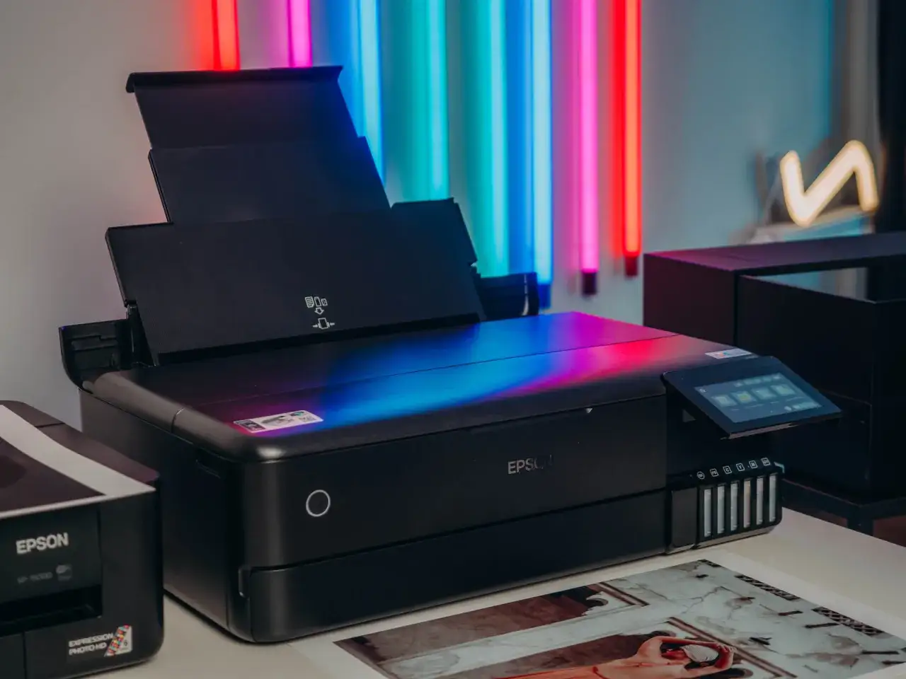 Nowoczesne urządzenie do robienia odbitek Epson, gotowe do drukowania zdjęć w żywych kolorach, otoczone neonowym światłem.
