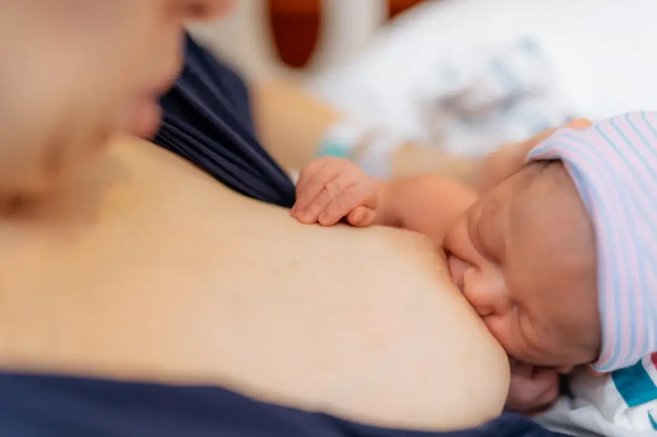 Nowa mama karmi piersią dziecko, co jest naturalne i bezpieczne, nawet po szczepieniu na COVID-19. Hafija.