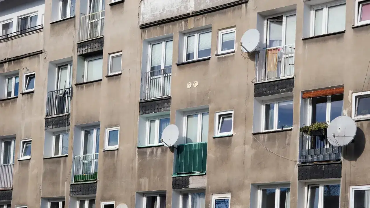Szare bloki mieszkalne z balkonami i antenami satelitarnymi. Czy wojsko daje mieszkanie w takich budynkach?