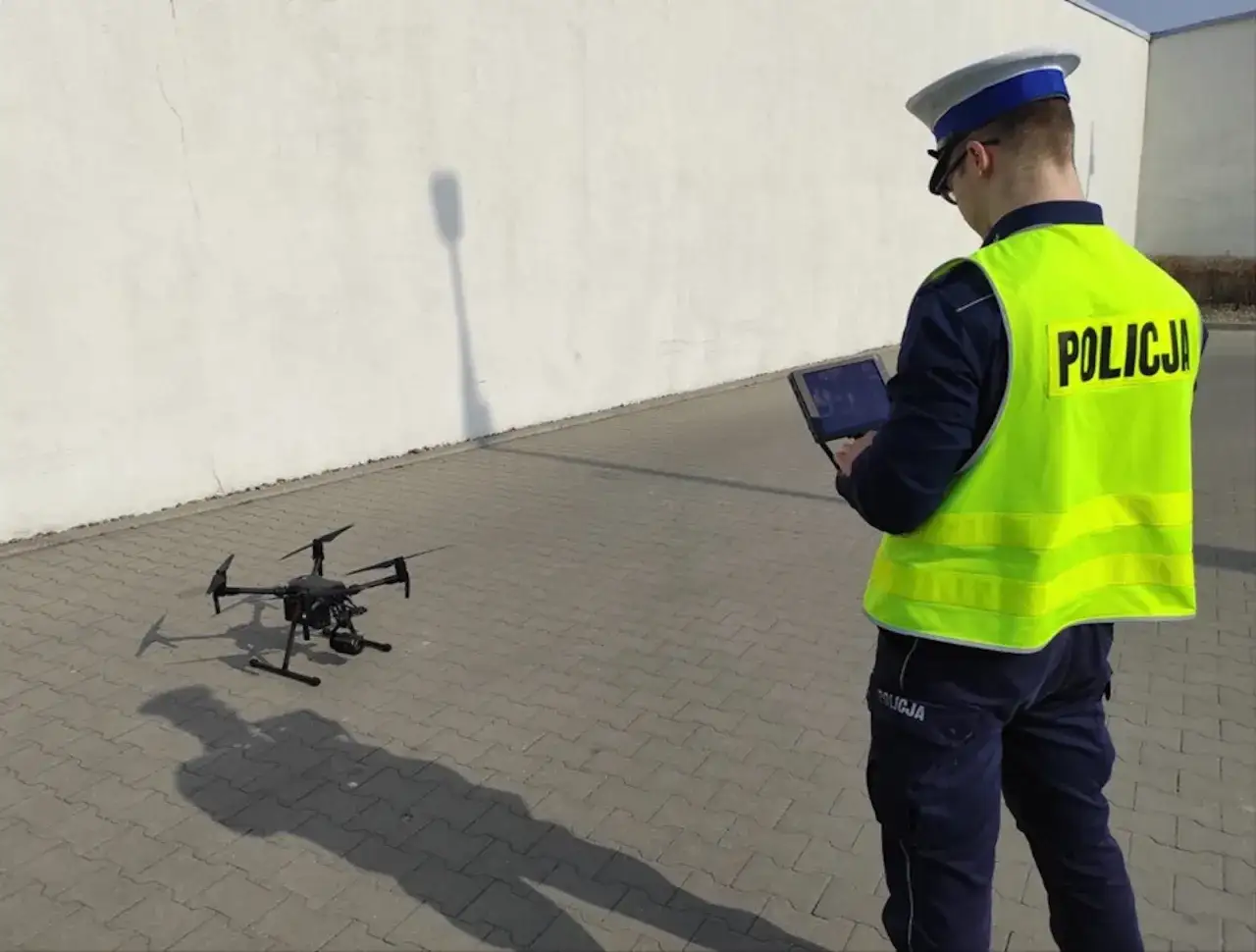 Policjant steruje dronem, który może pomóc ustalić, po jakim czasie przychodzi mandat z drona.