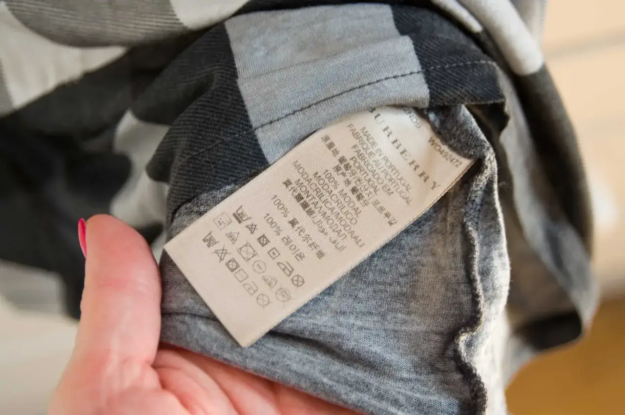 Metka z napisem Burberry, Made in Portugal. Sprawdź metkę, by dowiedzieć się, jak rozpoznać oryginał.