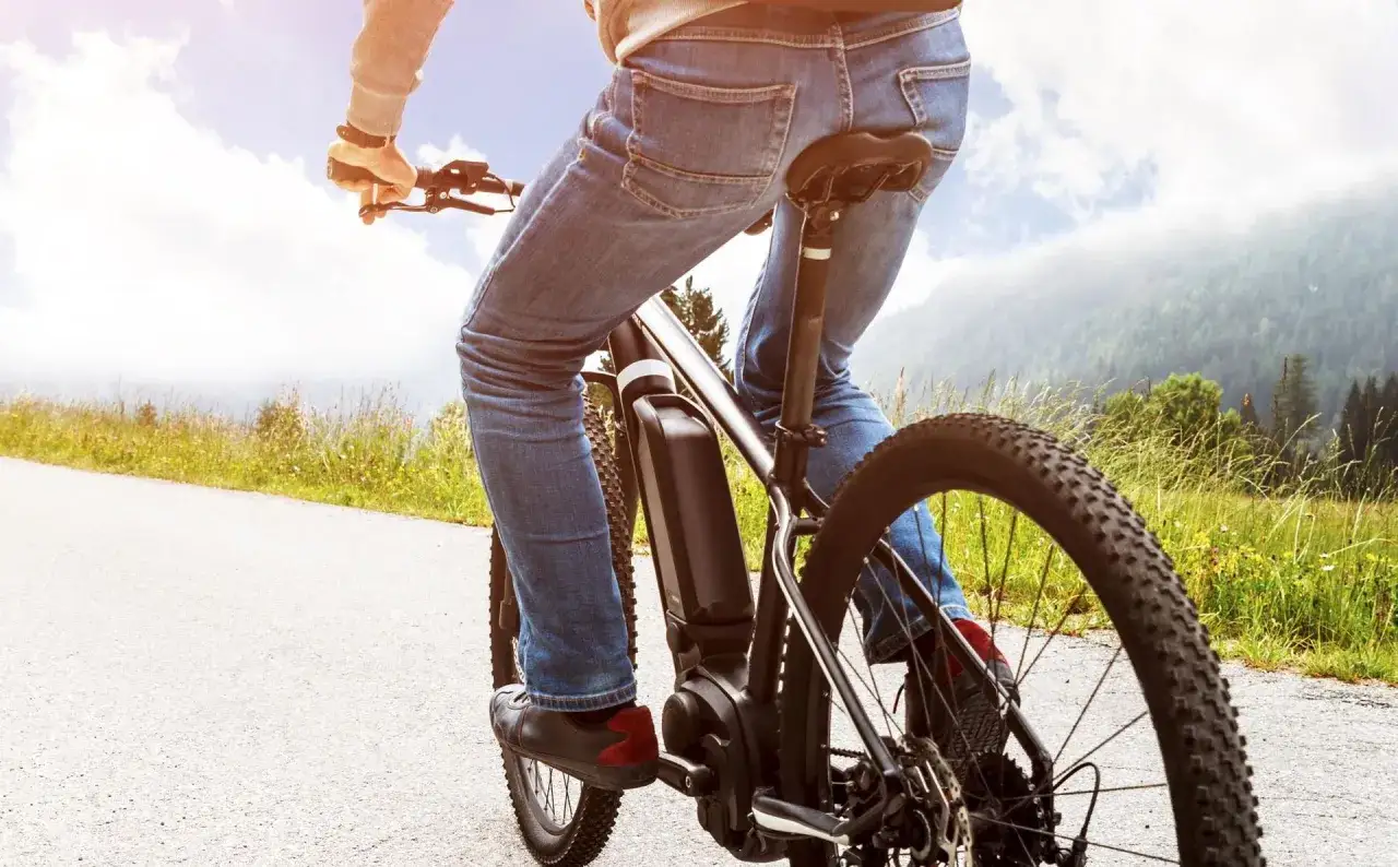 Osoba na rowerze elektrycznym cieszy się jazdą po malowniczej trasie. Dofinansowanie do roweru sprawia, że takie wycieczki są dostępne dla każdego.