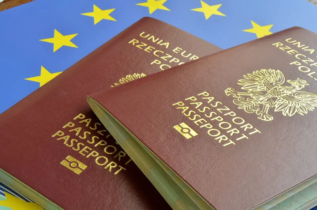 Dwa polskie paszporty na tle flagi Unii Europejskiej.