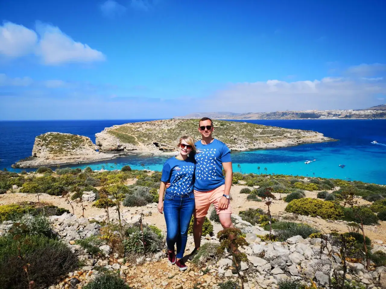 Para na tle turkusowej wody i skalistego krajobrazu Malty. Ile ludności ma Malta? Około 500 tysięcy.