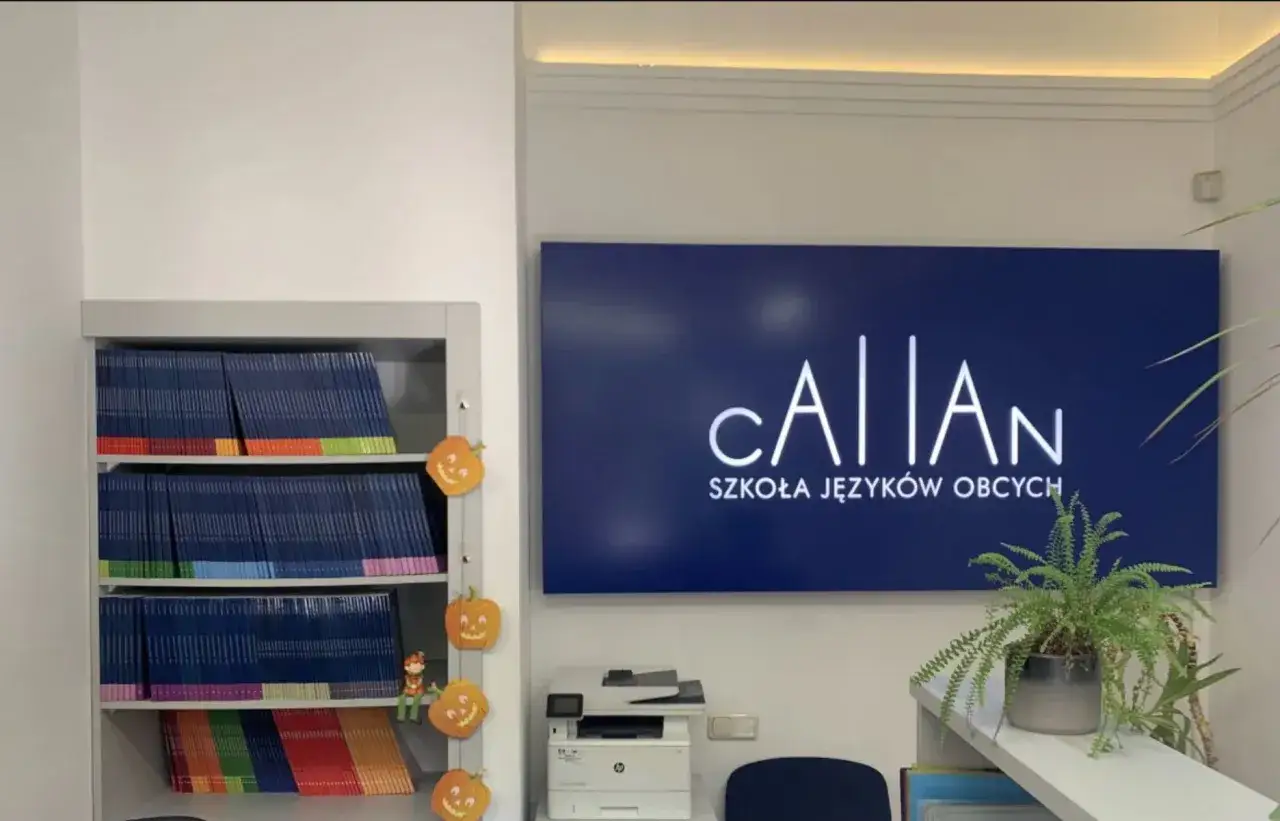 Szkoła językowa oferująca angielski metodą Callana. Na półkach książki, obok dynie. Na ścianie logo szkoły.